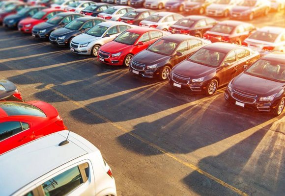 Na parkingu stoją różne modele aut i wszystkie wymagają opłacenia podatku od zakupu samochodu