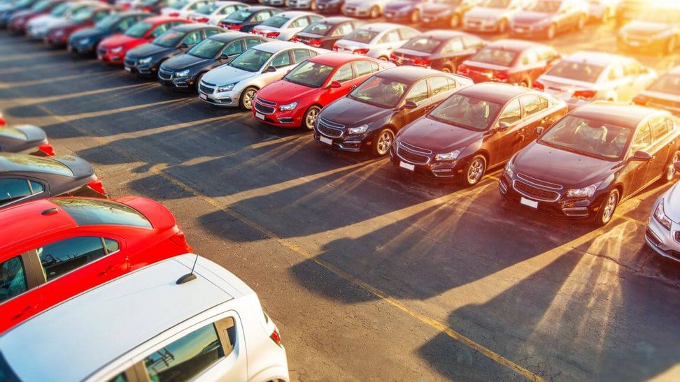 Na parkingu stoją różne modele aut i wszystkie wymagają opłacenia podatku od zakupu samochodu
