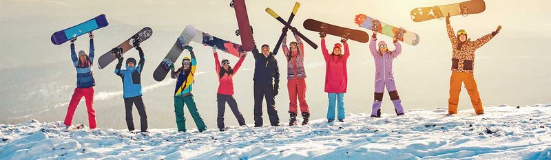 Happy friends skiers and snowboarders at ski resort