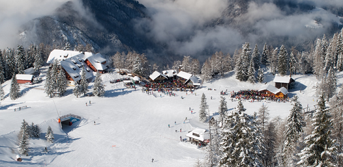 krvavec Widok z lotu ptaka na zimowy kurort narciarski Krvavec w Słowenii z trasami zjazdowymi, budynkami i lasem iglastym w otoczeniu mglistych gór