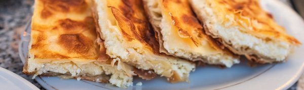 Byrek – tradycyjna albańska pieczeń z serem feta, podawana na śniadanie w stylu bałkańskim