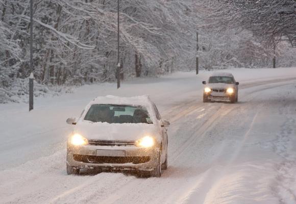 auta jadą po zaśnieżonej drodze