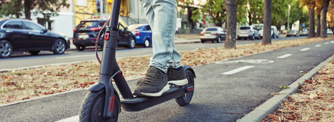 Osoba jadąca hulajnogą elektryczną po ścieżce rowerowej, ponieważ w tym miejscu nie można jeździć po ulicy