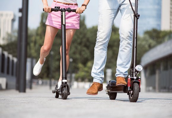 Jazda na hulajnodze elektrycznej zgodnie z najnowszymi przepisami prawa o ruchu drogowym Dwie osoby będące w wieku odpowiednim do jeżdżenia hulajnogą elektryczną jeżdżą hulajnogami po mieście