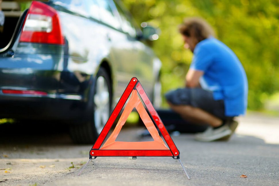 trójkąt ostrzegawczy zepsute auto w tle