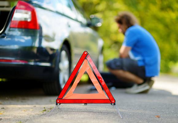 trójkąt ostrzegawczy zepsute auto w tle