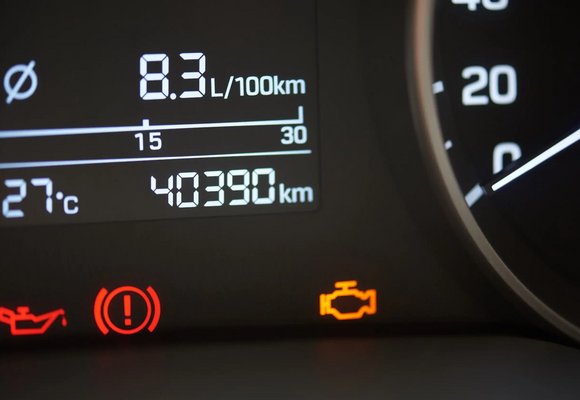 Zapalona kontrolka silnika i przypomnienie o wymianie oleju na desce rozdzielczej samochodu z widocznym przebiegiem pojazdu. Zapalona kontrolka silnika i przypomnienie o wymianie oleju na desce rozdzielczej samochodu z widocznym przebiegiem pojazdu.