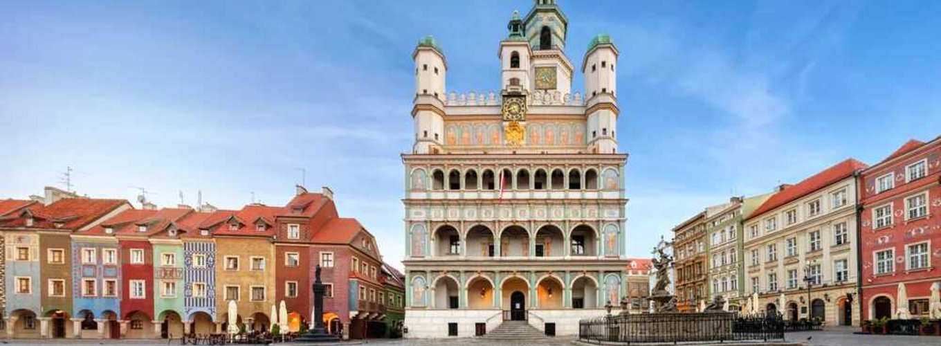 Rynek w Poznaniu z kolorowymi kamienicami i renesansowym ratuszem, idealny na spacer z karta EKUZ uprawniającą do korzystania z opieki zdrowotnej podczas podróży po krajach Unii Europejskiej.