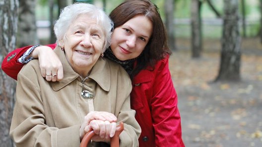 Dorosła wnuczka obejmuje swoją babcię emerytkę i pozują razem do zdjęcia