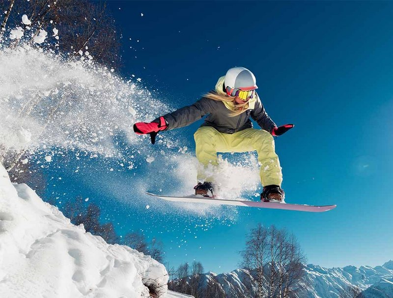 Girl is jumping with snowboard