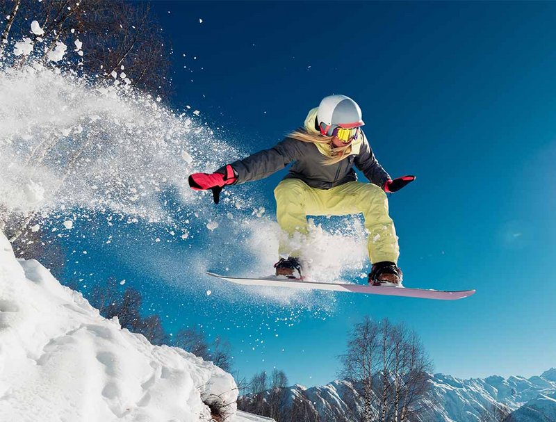 Girl is jumping with snowboard