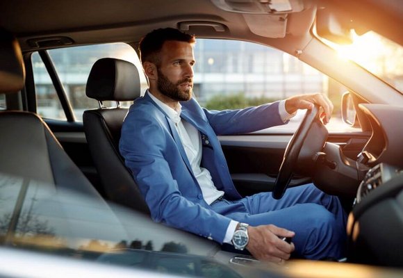 Elegancki mężczyzna prowadzi samochód sfinansowany za pomocą leasingu finansowego