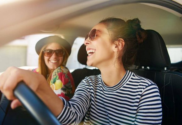 Dwie młode kobiety jadą samochodem i dyskutują na temat czy trzeba wozić OC ze sobą