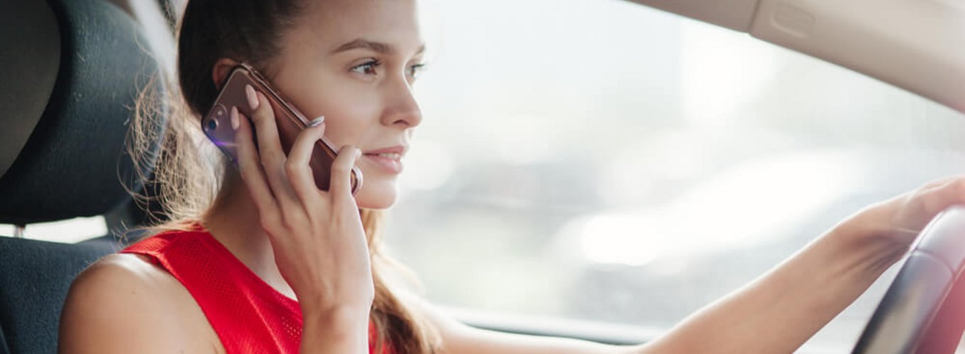 kobieta za kierownicą rozmawia przez telefon