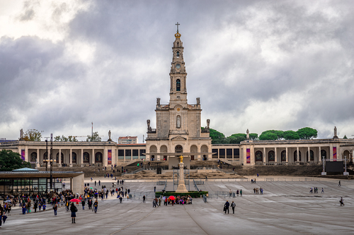 Sanktuarium Matki Bożej Fatimskiej w Portugalii z centralną bazyliką, wysoką wieżą dzwonniczą i dużym otwartym placem.