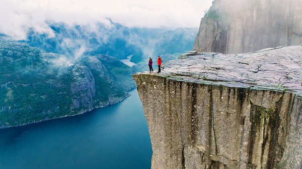 Breathtaking view from Preikestolen Cliff in Norway during a misty morning adventure