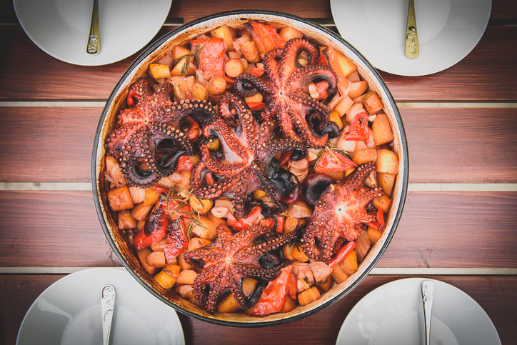 Preparing and Cooking of octopus in traditional Croatian peka Sa