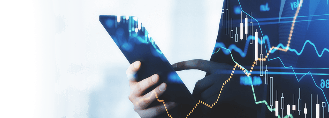 Osoba trzymająca tablet w rękach, zdjęcie przykryte jest wykresami.