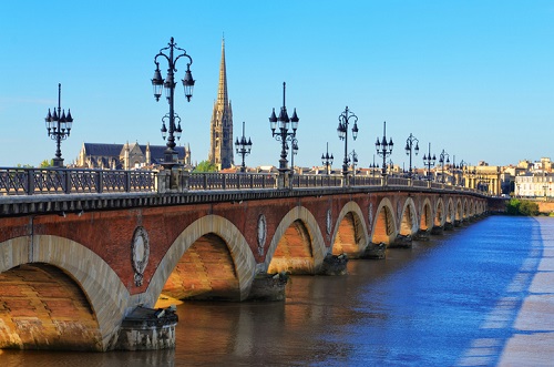 Bordeaux river bridge with St Michel cathedral in background Pont de Pierre w Bordeaux, Francja - malowniczy kamienny most z widokiem na historyczne budynki