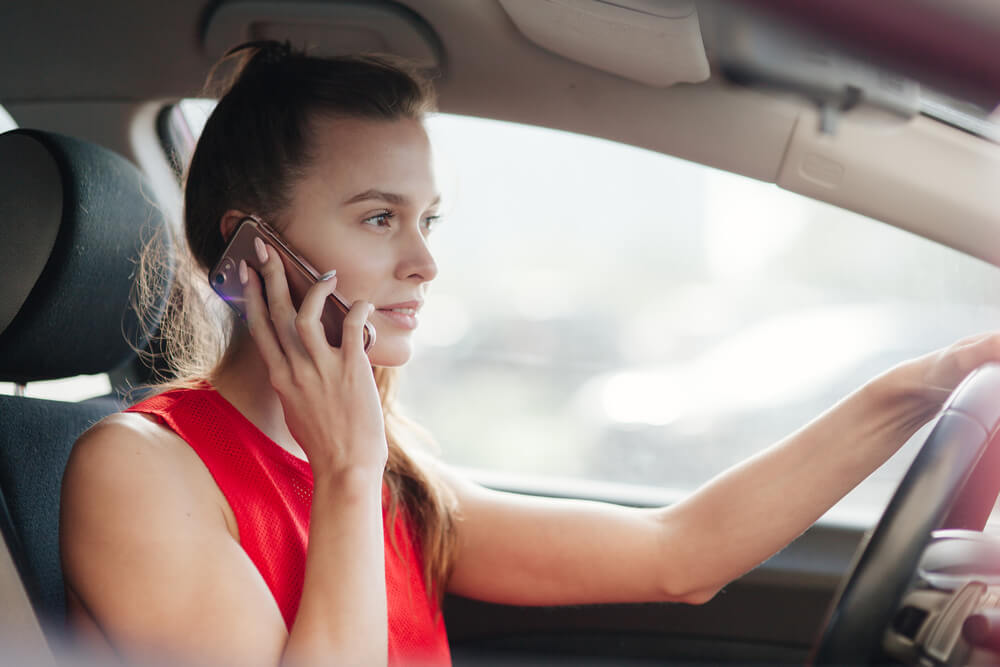 kobieta za kierownicą rozmawia przez telefon